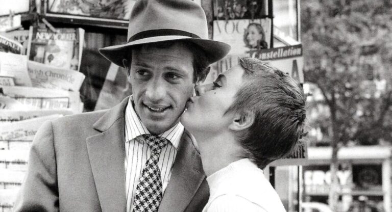 A woman kisses a man on the cheek in black and white